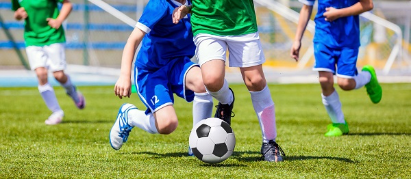 Young Soccer Players Running After the Ball. 