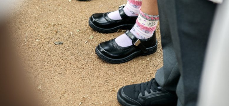 Children in school shoes stanging in a line